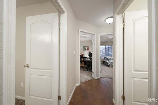 corridor with baseboards and dark wood finished floors