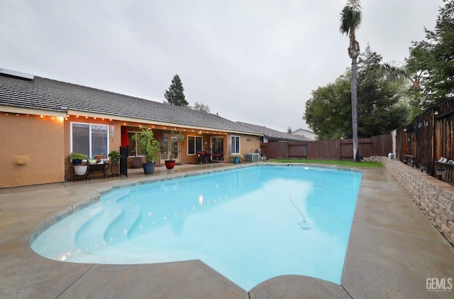 view of swimming pool featuring a fenced in pool, central AC, a patio area, and a fenced backyard