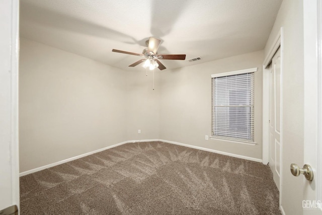 unfurnished bedroom with a closet, carpet, visible vents, and baseboards