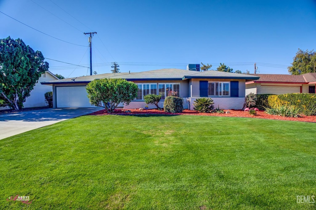 ranch-style house featuring a garage and a front yard