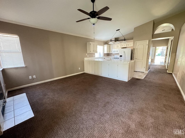 kitchen with white appliances, white cabinets, open floor plan, a peninsula, and light countertops