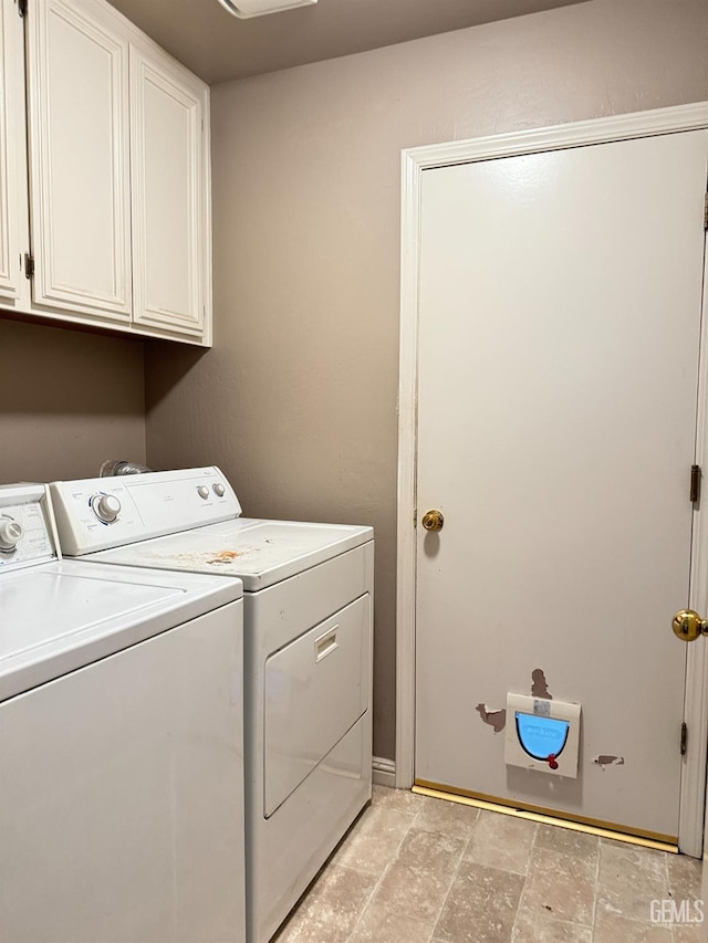 laundry room with stone finish floor, cabinet space, and separate washer and dryer