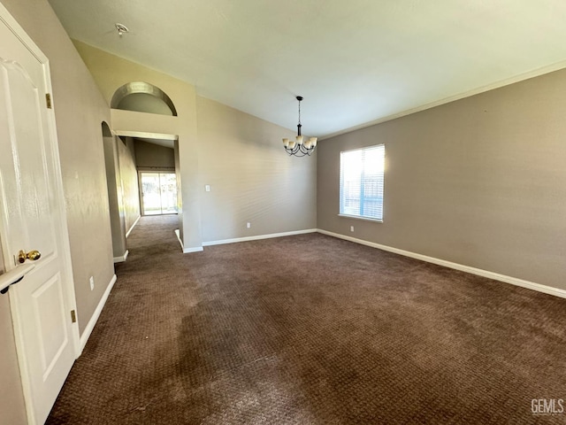 spare room with arched walkways, dark colored carpet, vaulted ceiling, a chandelier, and baseboards