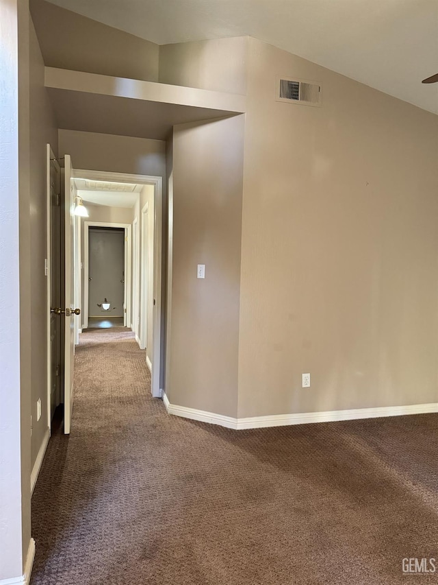 hallway with carpet flooring, visible vents, and baseboards