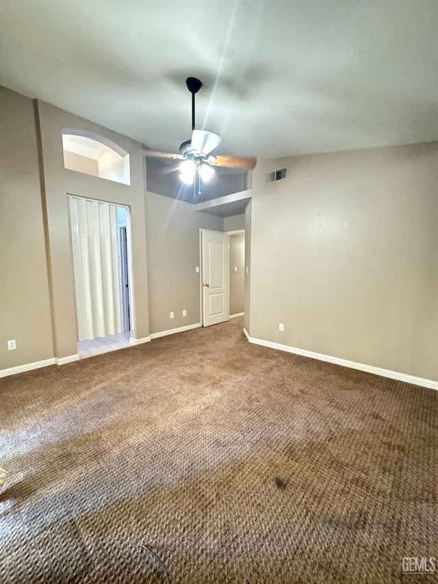 carpeted spare room featuring baseboards, visible vents, and a ceiling fan