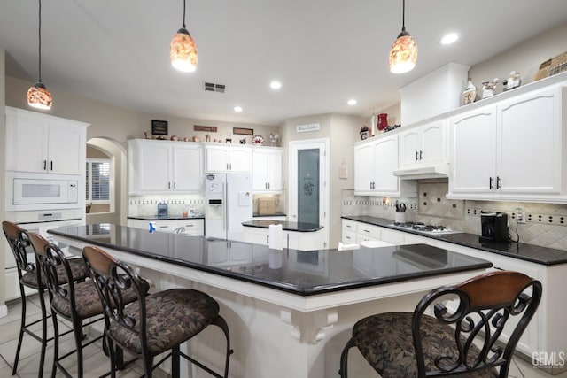 4400 Cron Way, Bakersfield, CA 93311 - kitchen with white appliances, dark countertops, under cabinet range hood, backsplash, and a large island