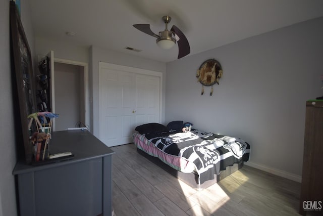 bedroom with ceiling fan, a closet, and hardwood / wood-style floors