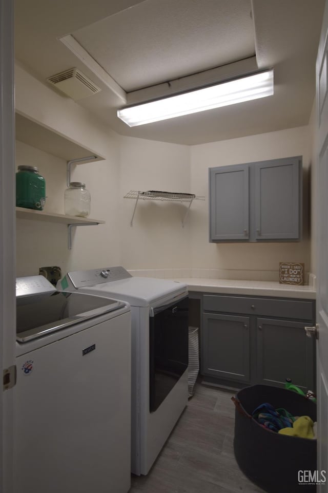 laundry area featuring washer and dryer, dark hardwood / wood-style floors, and cabinets