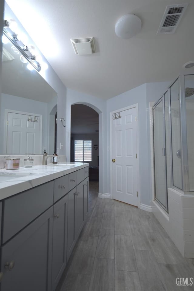 11712 Novara Ave, Bakersfield, CA 93312 - full bath featuring a shower stall, double vanity, wood finished floors, and baseboards