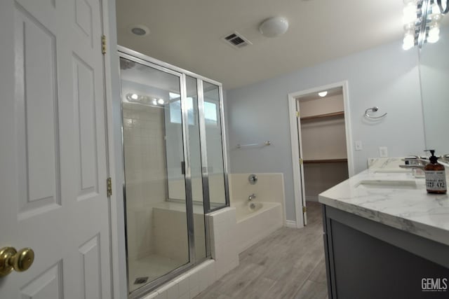 bathroom featuring hardwood / wood-style floors, vanity, and shower with separate bathtub