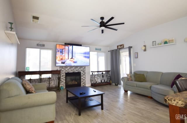 11712 Novara Ave, Bakersfield, CA 93312 - living room featuring lofted ceiling, ceiling fan, light wood-type flooring, healthy amount of natural light, and a fireplace