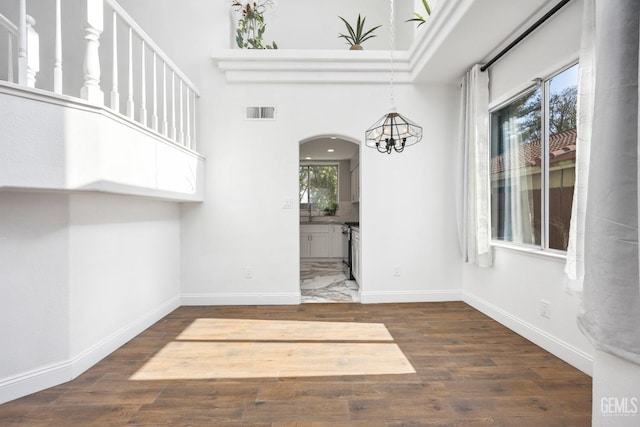 unfurnished dining area with dark wood-type flooring