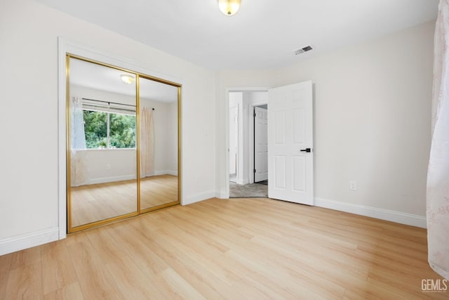 unfurnished bedroom with light hardwood / wood-style flooring and a closet