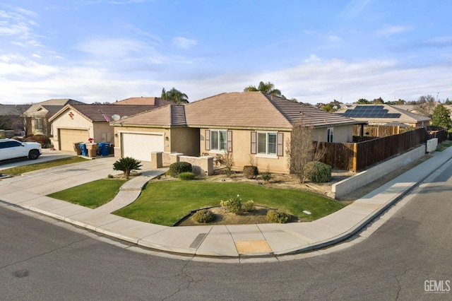 ranch-style home with solar panels, a garage, and a front lawn