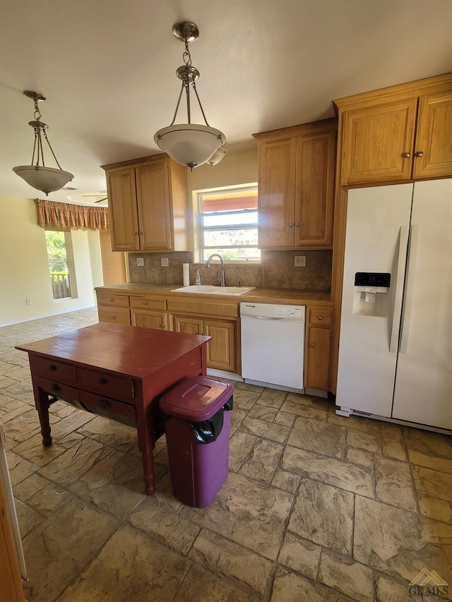 kitchen with decorative light fixtures, white appliances, sink, and tasteful backsplash