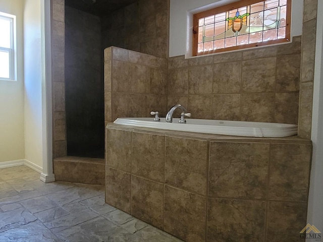 bathroom with a relaxing tiled tub