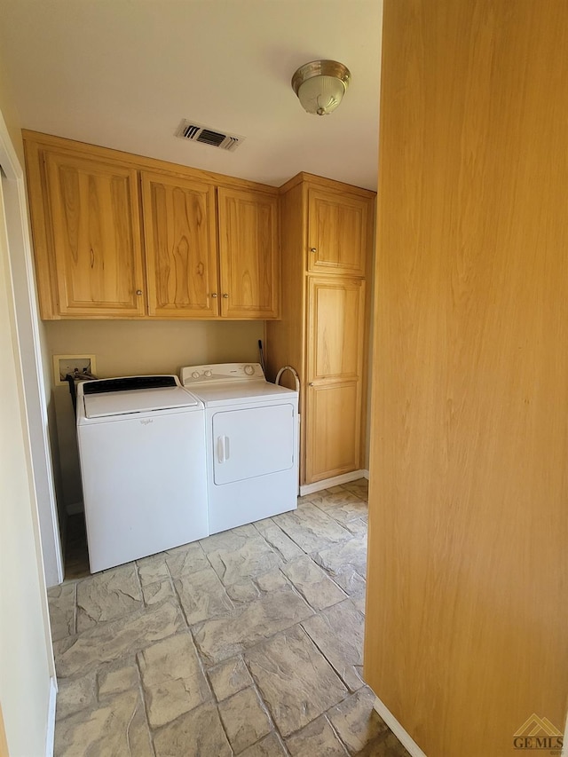 laundry area featuring cabinets and washing machine and clothes dryer