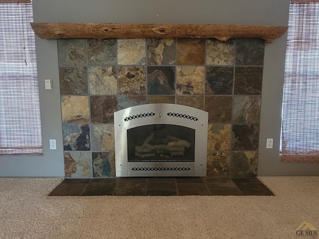 details with carpet flooring, a tiled fireplace, and heating unit