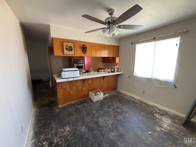2710 Maher Way, Bakersfield, CA 93312 - kitchen featuring stainless steel oven, brown cabinetry, baseboards, ceiling fan, and a peninsula