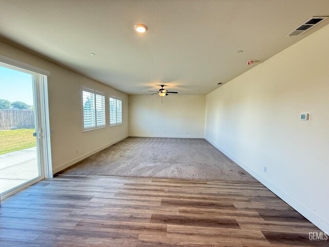 spare room featuring a ceiling fan, baseboards, and wood finished floors