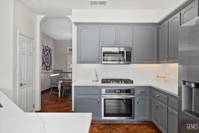 4504 Polo Club Dr, Bakersfield, CA 93312 - kitchen with stainless steel appliances, gray cabinets, light stone countertops, and dark tile patterned floors