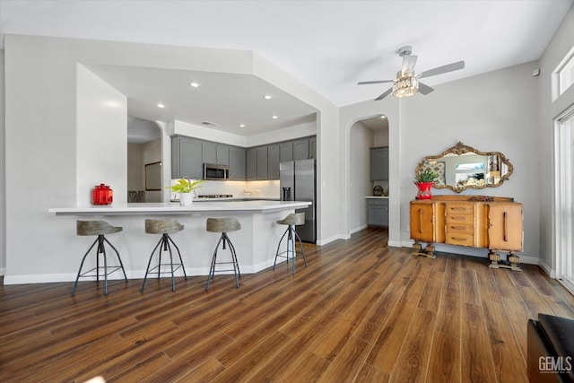 4504 Polo Club Dr, Bakersfield, CA 93312 - kitchen with appliances with stainless steel finishes, gray cabinetry, a kitchen bar, a peninsula, and recessed lighting