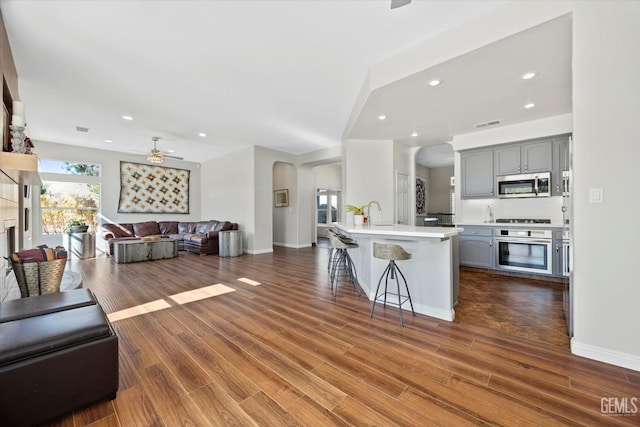 4504 Polo Club Dr, Bakersfield, CA 93312 - kitchen with stainless steel appliances, arched walkways, ceiling fan, open floor plan, and recessed lighting