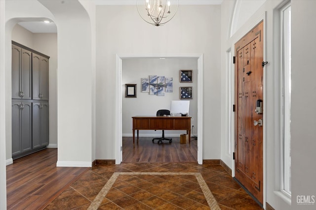 4504 Polo Club Dr, Bakersfield, CA 93312 - foyer with inlaid floor details, arched walkways, dark wood-style floors, and a chandelier
