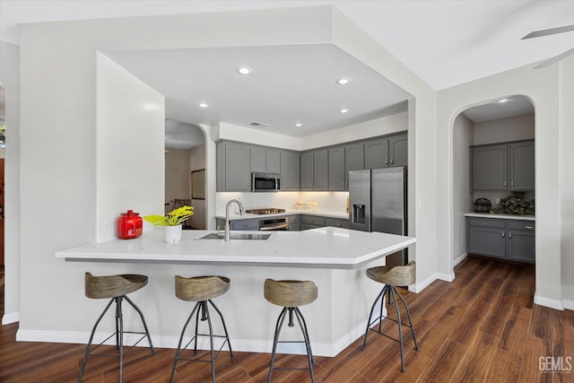 4504 Polo Club Dr, Bakersfield, CA 93312 - kitchen with appliances with stainless steel finishes, gray cabinetry, a peninsula, a kitchen bar, and recessed lighting