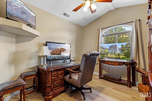 office featuring ceiling fan, visible vents, light wood-style flooring, and vaulted ceiling