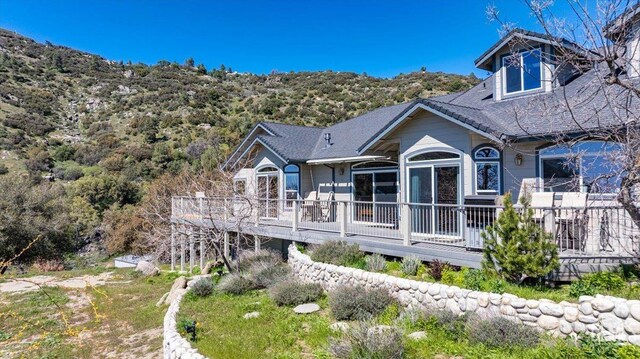rear view of property featuring a wooden deck