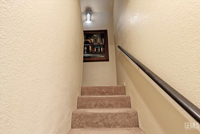 stairs featuring a textured wall