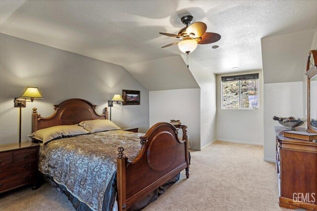 bedroom featuring light carpet, a textured ceiling, a ceiling fan, baseboards, and vaulted ceiling
