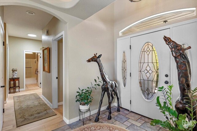entryway with arched walkways and baseboards