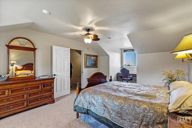 bedroom featuring a ceiling fan, a textured ceiling, vaulted ceiling, and light carpet