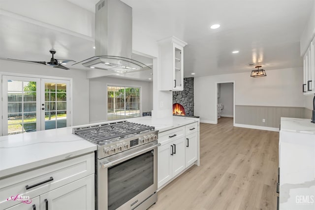 6405 Hesketh Dr, Bakersfield, CA 93309 - kitchen featuring stainless steel range with gas cooktop, island exhaust hood, a ceiling fan, white cabinets, and recessed lighting
