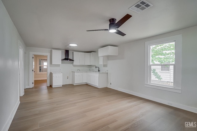 710 Fillmore St, Taft, CA 93268 - kitchen featuring light wood-style flooring, visible vents, baseboards, ceiling fan, and wall chimney range hood