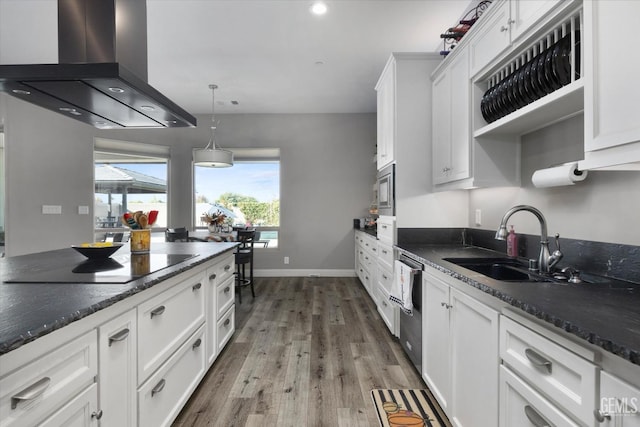 kitchen with pendant lighting, white cabinets, sink, black electric cooktop, and island exhaust hood