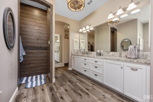 bathroom featuring hardwood / wood-style floors, vanity, and a shower