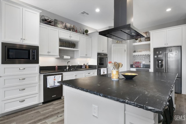 kitchen featuring white cabinetry, built in microwave, island range hood, and sink