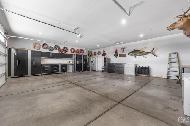 garage featuring stainless steel refrigerator with ice dispenser