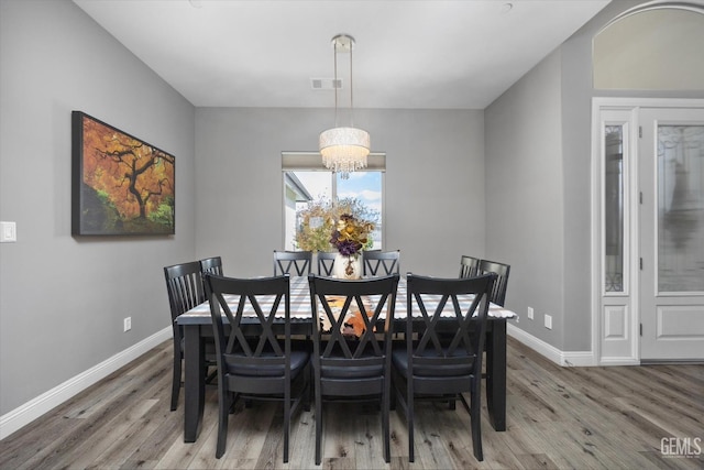 dining room featuring hardwood / wood-style flooring and an inviting chandelier