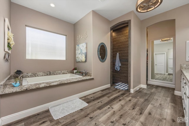 bathroom featuring shower with separate bathtub, vanity, and hardwood / wood-style flooring