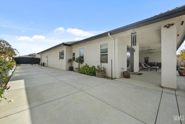 view of side of property featuring a patio area, ceiling fan, and outdoor lounge area