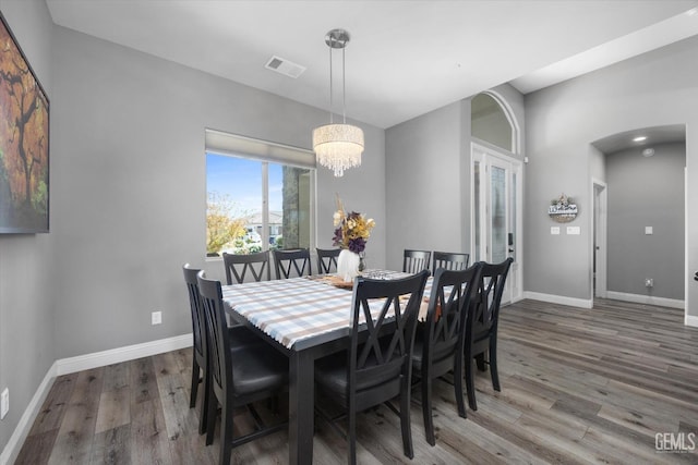 dining space featuring a notable chandelier and dark wood-type flooring