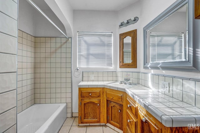 bathroom with tile patterned floors, vanity, tiled shower / bath, and decorative backsplash