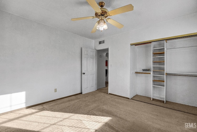 unfurnished bedroom featuring carpet floors, a closet, and ceiling fan