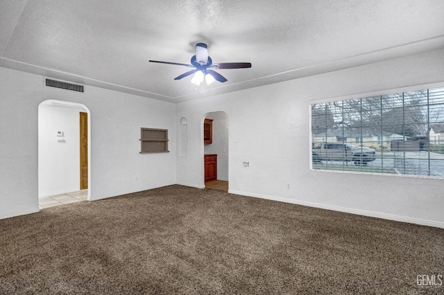 carpeted empty room featuring a textured ceiling and ceiling fan