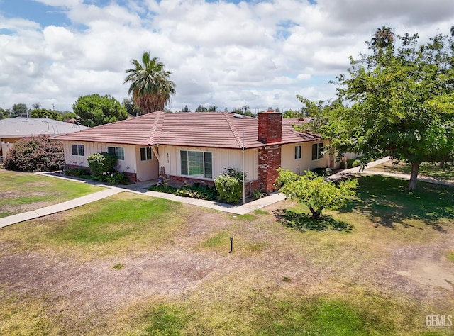 6513 Desmond Ct, Bakersfield, CA 93308 - ranch-style home featuring board and batten siding, a tile roof, a chimney, and a front lawn