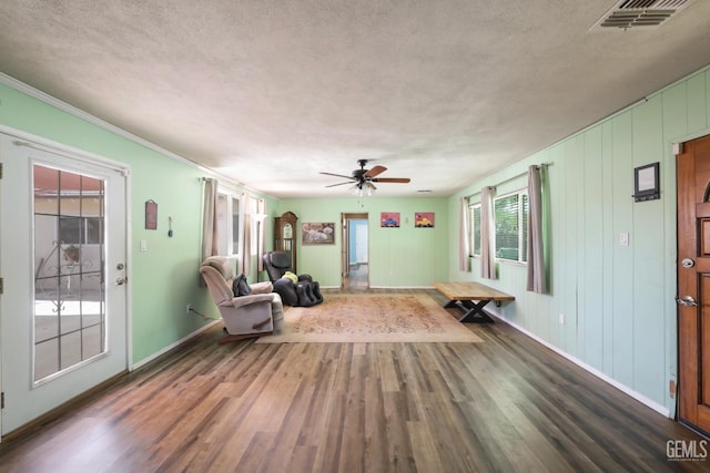 6513 Desmond Ct, Bakersfield, CA 93308 - unfurnished living room with wood finished floors, a textured ceiling, a ceiling fan, and crown molding